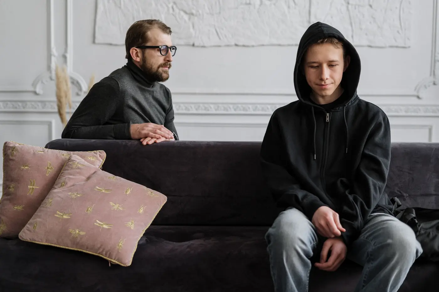A support worker sitting with a teenager and listening to him
